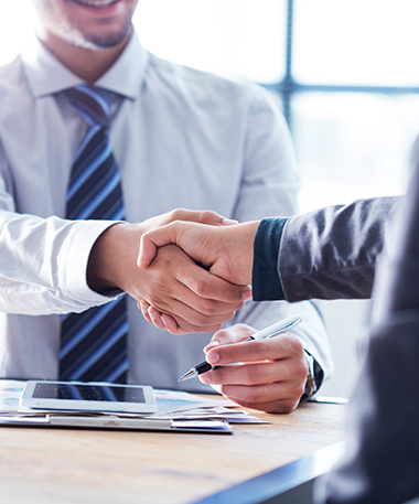 An investment advisor shakes the hand of a client.